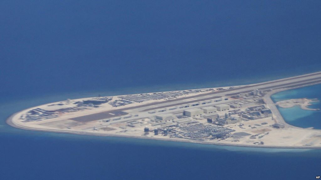 菲律宾空军一架运输机在南中国海南沙群岛的中国制造的人造岛礁渚碧礁上空飞越时拍摄的照片，显示人造岛礁上的简易机场和建筑物。（2017年4月21日）