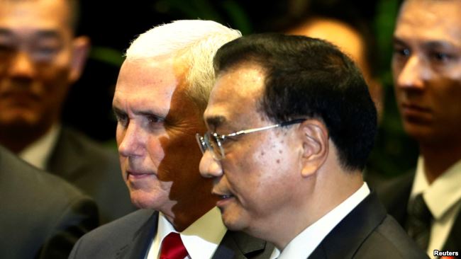 美国副总统彭斯与中国总理李克强在新加坡东盟峰会上交谈。（2018年11月15日）