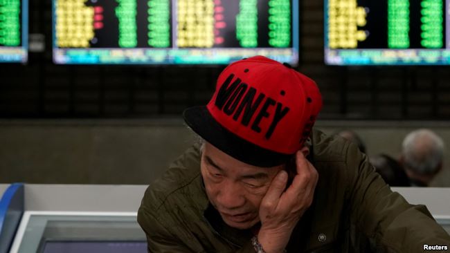 一名男子2019年5月6日在上海一家股市交易所查看股市行情。
