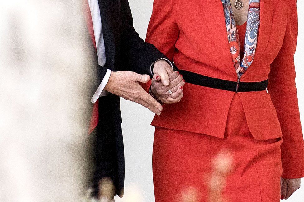 Theresa May and Donald Trump holding hands