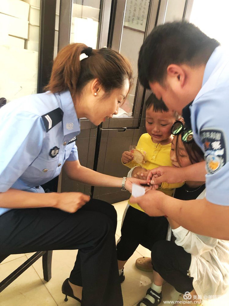 陕西省九峰派出所的警察采集一名男孩的DNA样本。