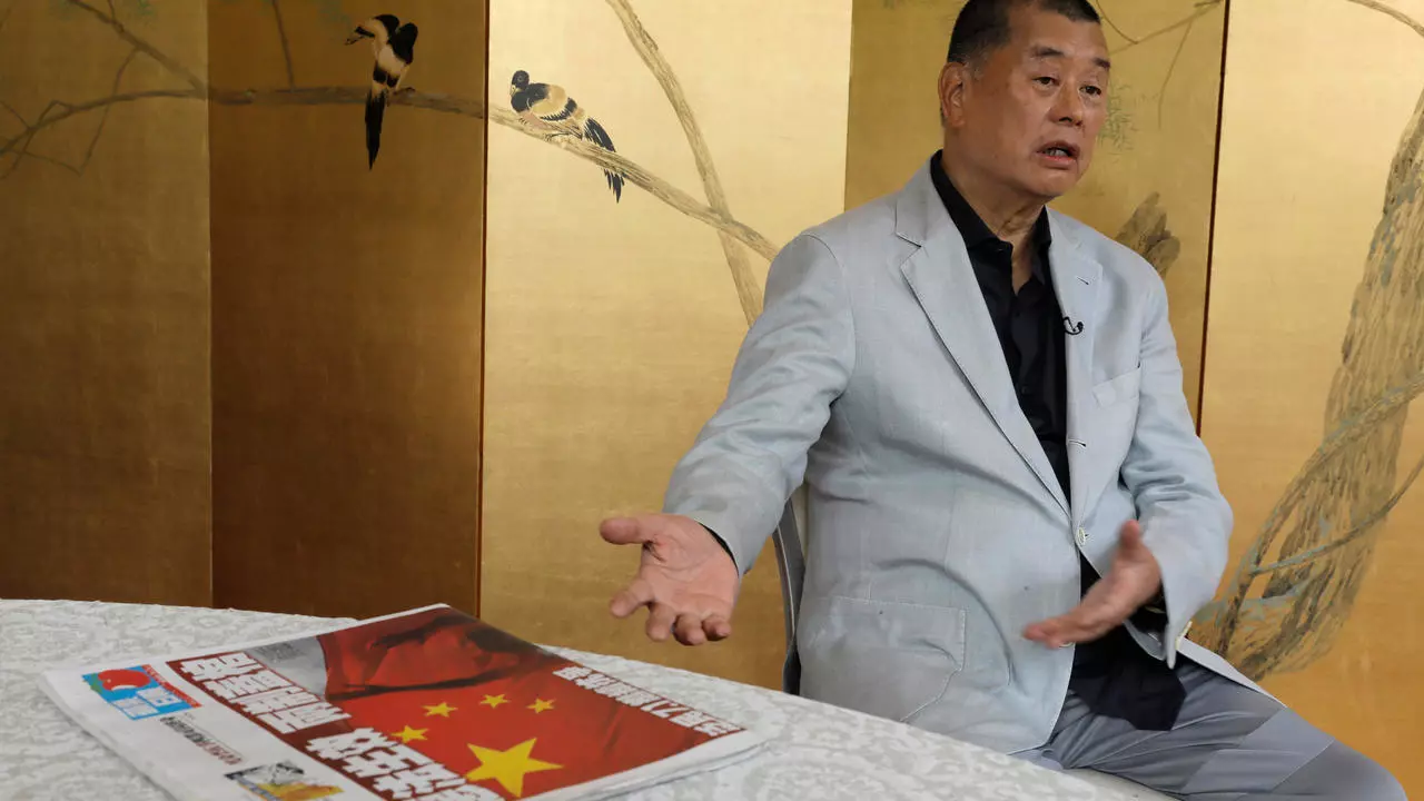 Hong Kong media tycoon Jimmy Lai gesture next to a copy of Apple Daily's July 1 edition during an interview Hong Kong Wednesday, July 1, 2020. Lai said in an interview Wednesday that Hong Kong is dead under the new national security law. Lai, who owns popular newspaper Apple Daily, is a prominent advocate for democracy in Hong Kong. (AP Photo/Vincent Yu)
