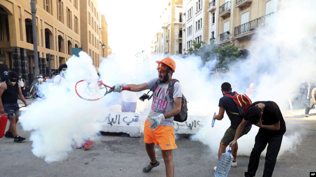 黎巴嫩反政府抗议者用网球拍击回防爆警察发射的一枚催泪弹。(2020年8月10日)