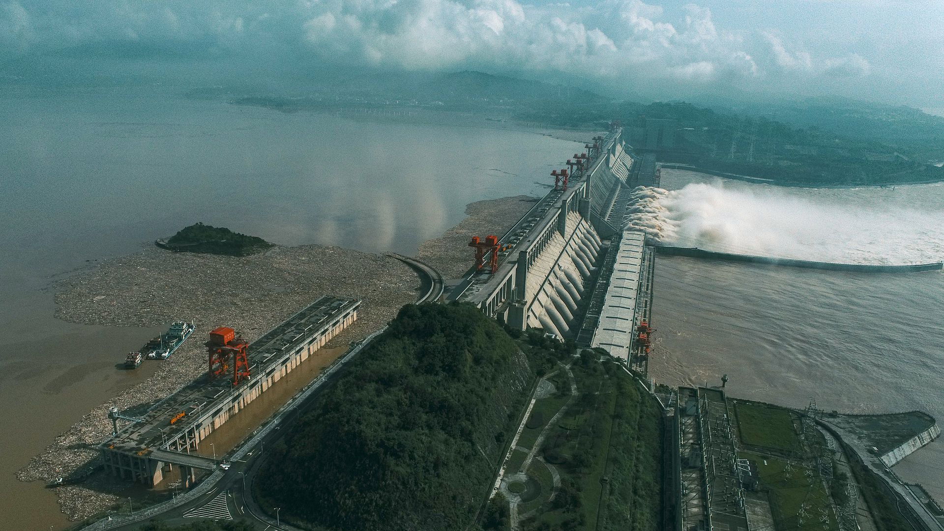 8月23日，工人在湖北宜昌的三峡水利枢纽三峡大坝前打捞渣草垃圾。