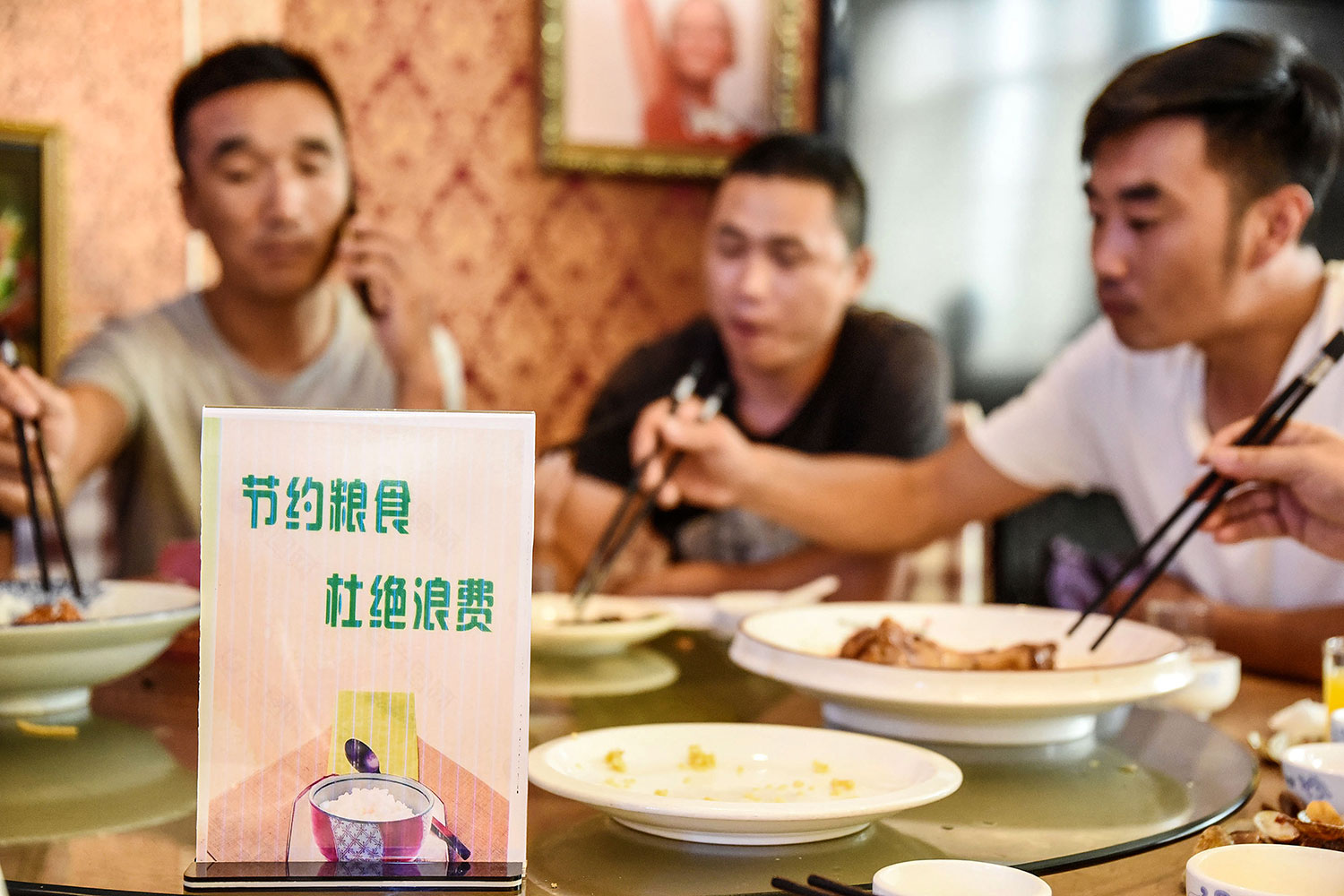 2020年8月13日，河北邯郸一家餐厅餐桌上摆放节约粮食的宣传牌，“节约粮食，杜绝浪费“。（AFP）