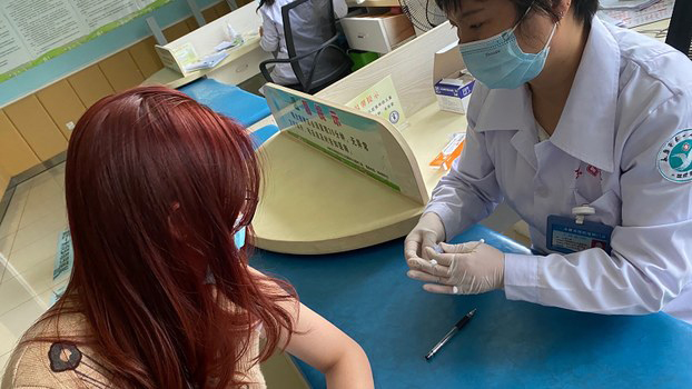 一名中国学生在接受注射新冠疫苗（法新社）