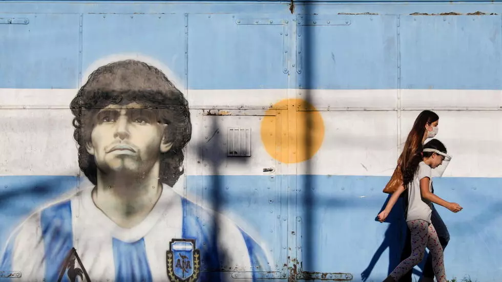 11月27日，行人路过布宜诺斯艾利斯街头的马拉多纳人物肖像