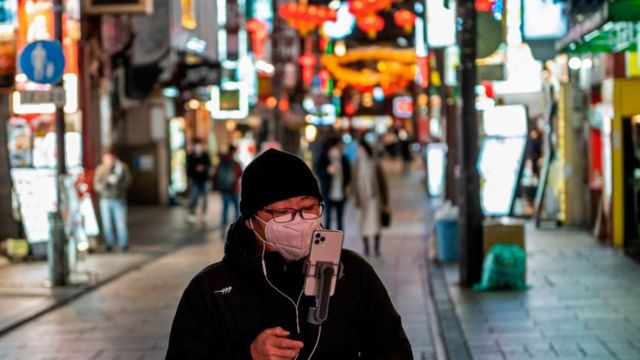 A man walks with his phone through Yokohama's Chinatown