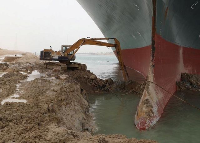 岸上的挖掘机负责清理船头周围的沙石泥土