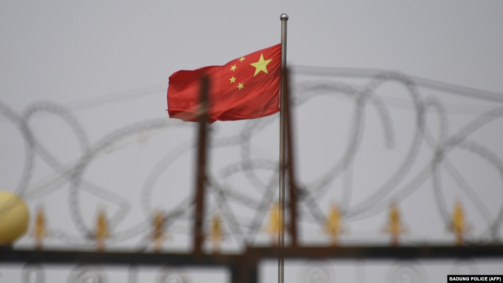 新疆喀什附近一个营地墙上的铁丝网和营地内的中国国旗。（2019年6月4日）