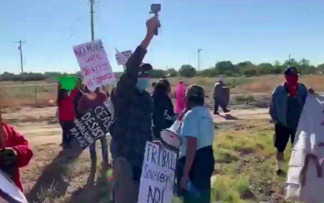 Dozens of Shiprock residents protest against cannabis farms holding signs reading: Resist marijuana farms