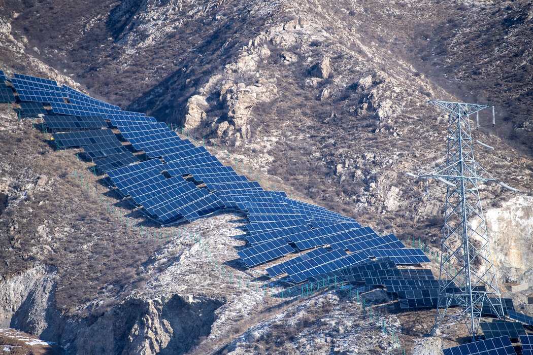 一个山坡上铺满了太阳能电池板，这是北京在清洁能源方面努力的另一个标志。