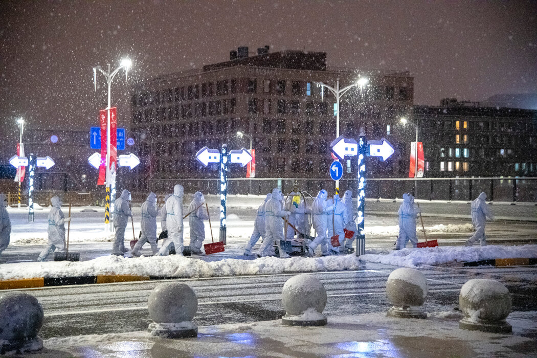 工作人员在北京的奥运火车站外清除积雪。