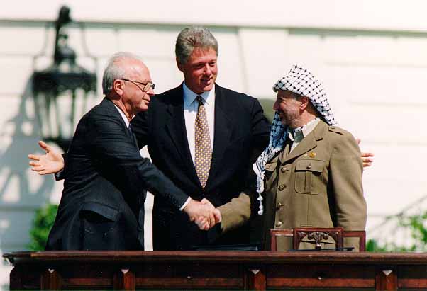 1993年9月13日，時任以色列總理拉賓（Yitzhak Rabin，左）與前巴勒斯坦解放組織主席阿拉法特（Yasser Arafat）在美國白宮草坪會面，中為時任美國總統柯林頓（William Clinton）。 圖：翻攝自維基百科