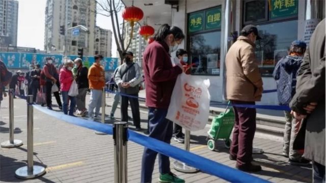 中国持续的封锁措施将对经济造成影响（图为人们排队在北京的一家商店购买食品）。