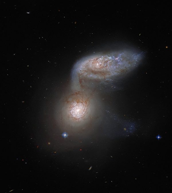 两个螺旋星系看似重叠 犹如太空中的蜗牛