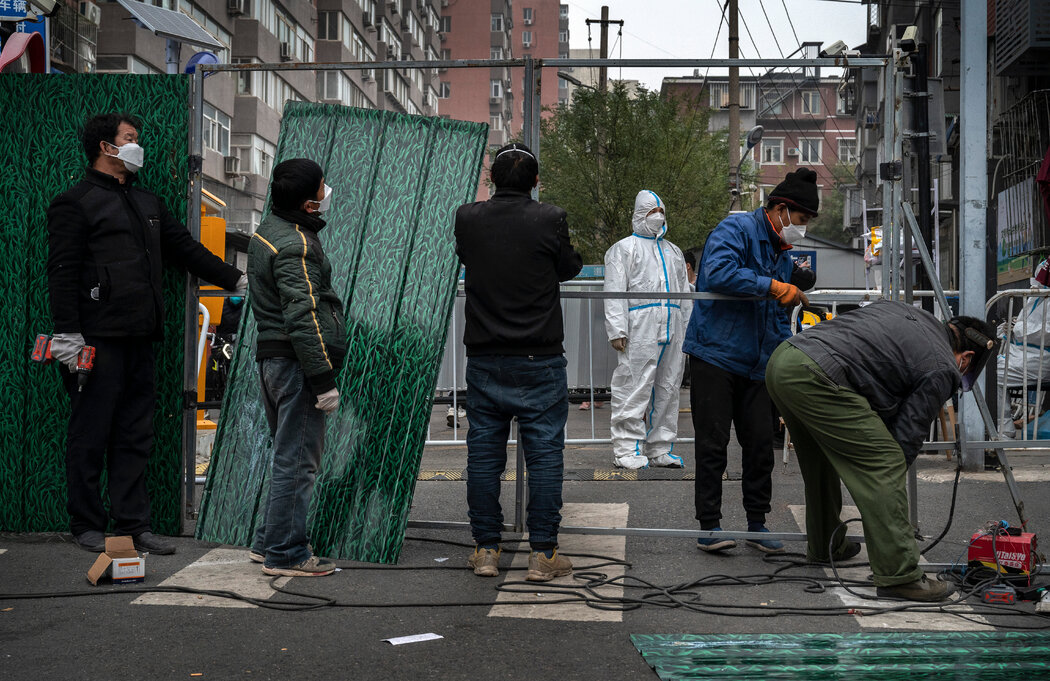 工人在北京一个封控小区外安装金属屏障，摄于今年11月。