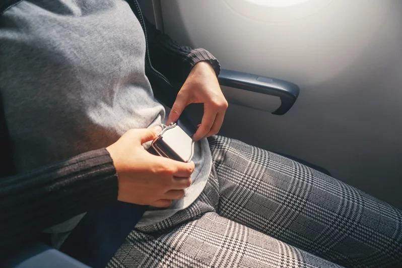 在搭机时应系好安全带，并避免穿着紧身裤等人造纤维材质的衣物。（示意图／ingimage）