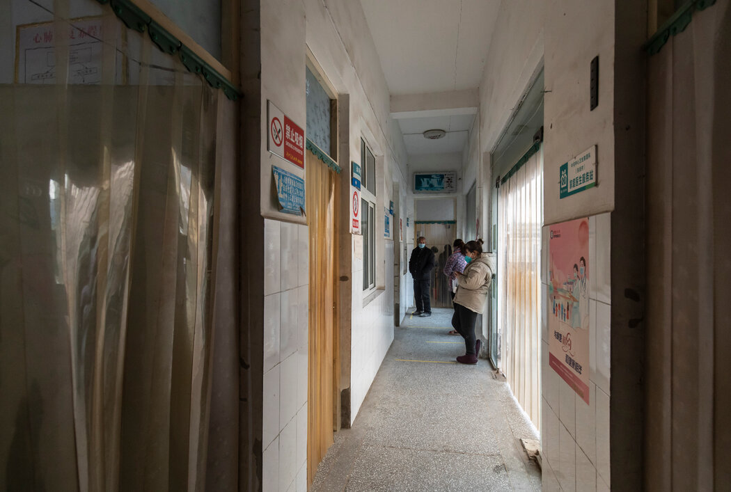 河南一家社区卫生中心走廊里等待看病的新冠病毒感染者，摄于今年1月。虽然近期感染病例增加可能会给医院带来压力，但许多人感染后似乎更愿意呆在家里自愈。