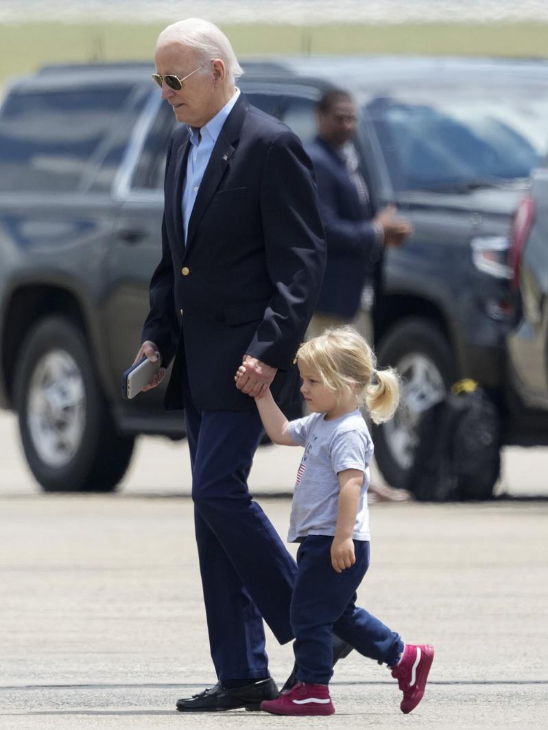 拜登总统24日在安德鲁空军基地手牵着孙子准备登机；NBC最新民调，拜登总统以49%对45%领先前总统川普。（美联社）