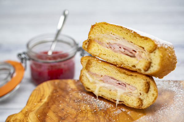 Caption: Battered & Fried Monte Cristo is a delicious and filling option with sliced turkey, ham and Swiss cheese with seasonal preserved and a choice of Pommes Frites or Petite Salad.