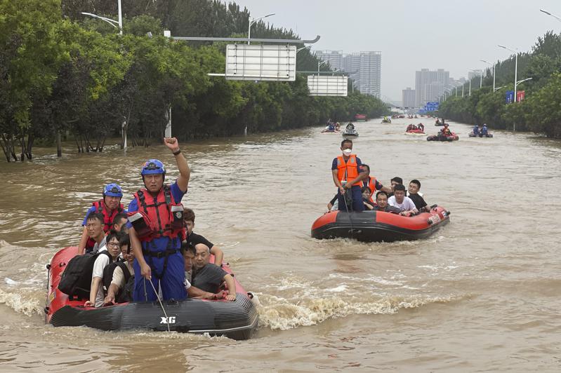 涿州居民乘橡皮艇穿过洪水疏散。(美联社)