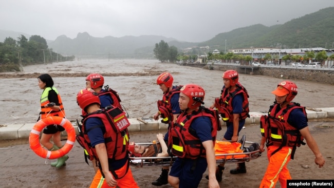 中国救援人员在北京门头沟区救助遭洪水泛滥袭击的民众。（2023年8月1日）