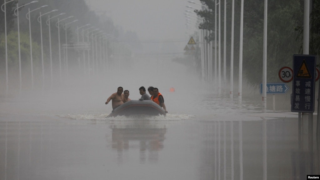 中国河北涿州民众在滔滔洪水中乘坐橡皮艇逃生。（2023年8月3日）