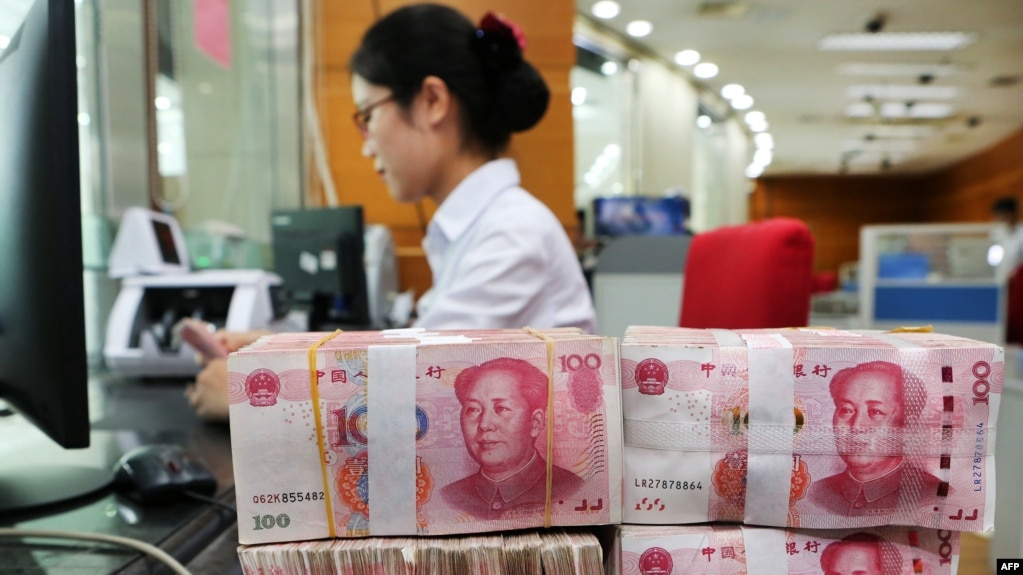 2018年7月23日在中国江苏省南通市的一家银行，一名员工处理100元纸币。