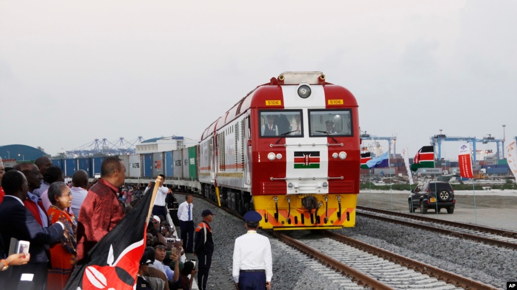 资料照片：时任肯尼亚总统肯雅塔(左三)出席开通仪式，观看标轨铁路集装箱货运列车离开蒙巴萨的港口集装箱库区驶往内罗毕。(2027年5月30日)