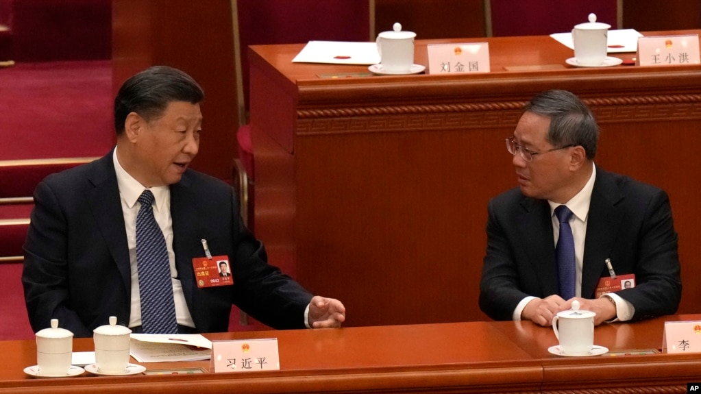 资料照片：中国国家主席习近平2023年3月12日在全国人民代表大会上与中国总理李强交谈。