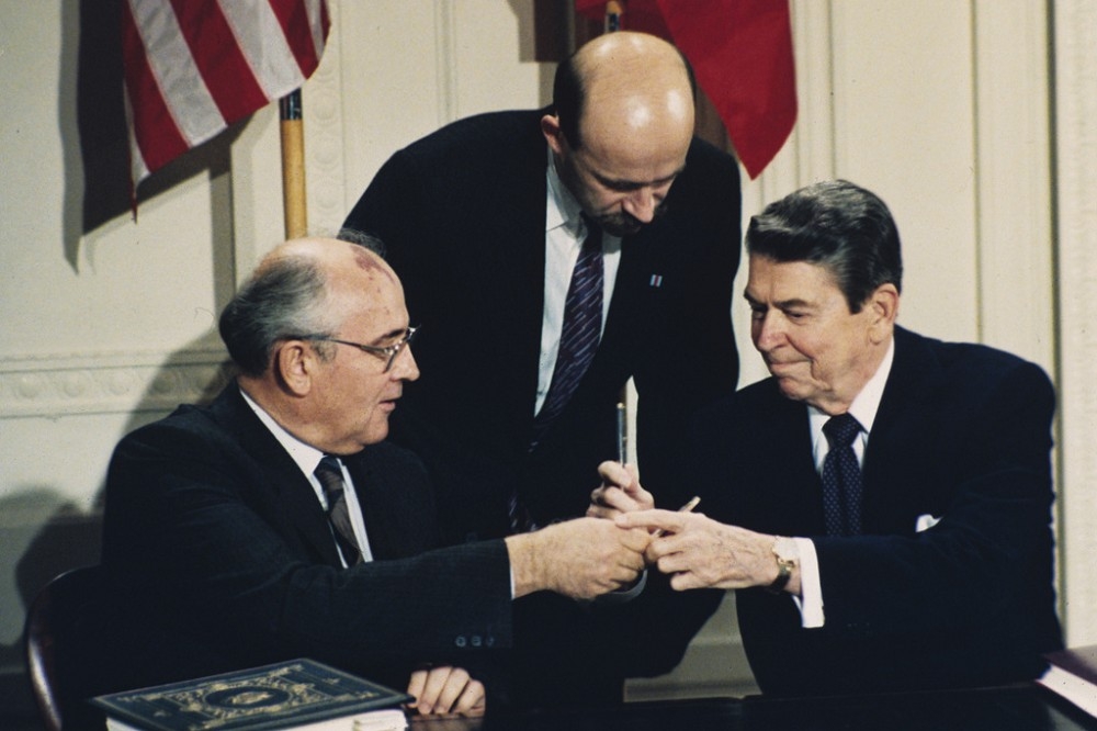 美蘇兩強冷戰時期為避免擦槍走火，因此協商簽署許多軍備限制條約。圖為1987年蘇聯領導人戈巴契夫（左）與美國總統雷根（右）簽署《中程核子力量條約》。（資料照片／美聯社）