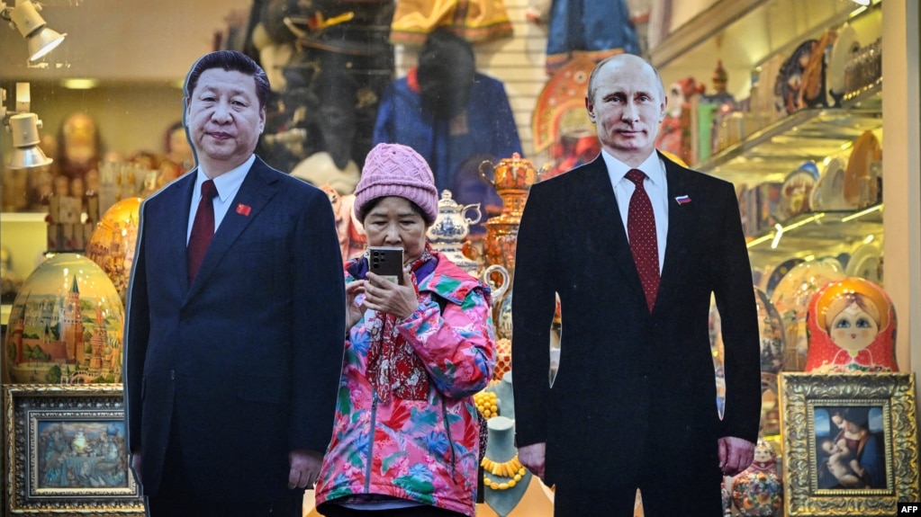 莫斯科街头一家旅游纪念品商店外树立的中俄领导人习近平和普京的纸板画像。（2023年11月15日）