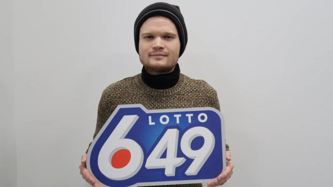lotto 6/49 winner oleksii shypylenko holding a lotto 6/49 sign