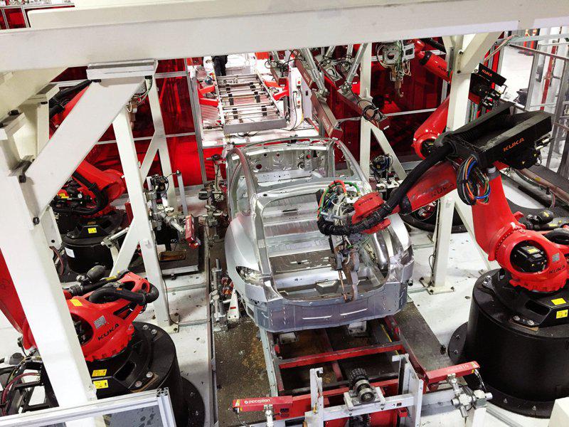 特斯拉汽车工厂里大量使用自动化的机器人手臂。（路透）