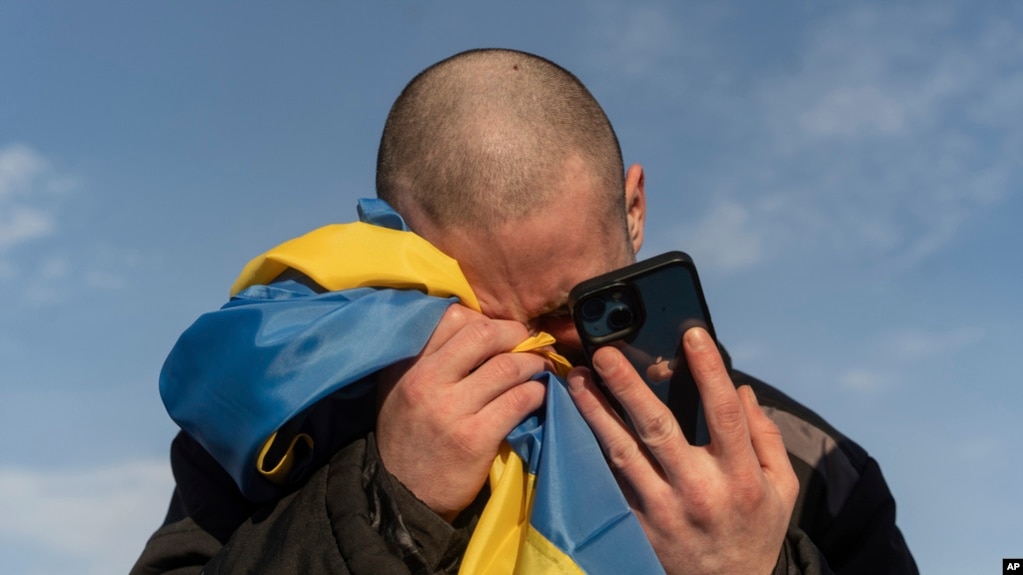 资料照片： 2024年1月31日，一名乌克兰战俘在乌克兰-俄罗斯边境交换战俘后打电话给亲戚时哭泣。（美联社照片）
