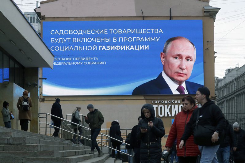 俄罗斯从今天起展开3天大选，连遭俄国占领的乌克兰领土都要投票，而反对派候选人都未获准参选。 图为民众走过普汀在街头的广告牌。 （欧新社）