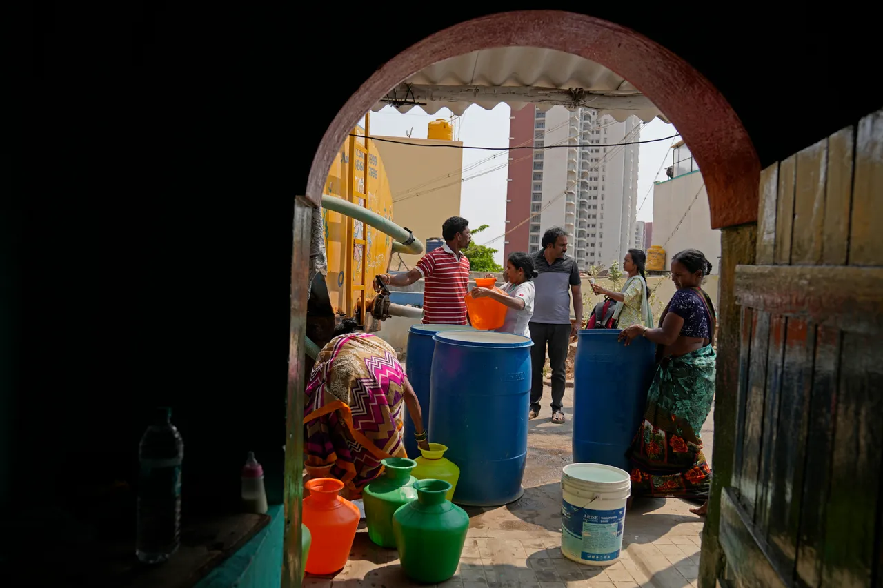 邦加羅爾外圍貧民區居民聽到載水車要來，拿出家裡各式水桶來買水備用。美聯社