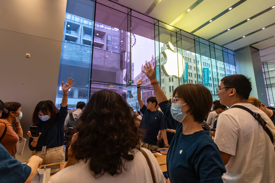 顾客在上海一家苹果店排队购买新款iPhone 15，摄于去年9月。