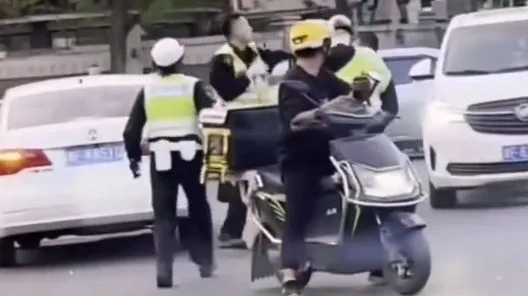 2名男性交通警察當街互毆，女警制止無效，機車騎士看傻眼了，就停在路中央。翻攝微博/天津市交通總隊和平交警支隊