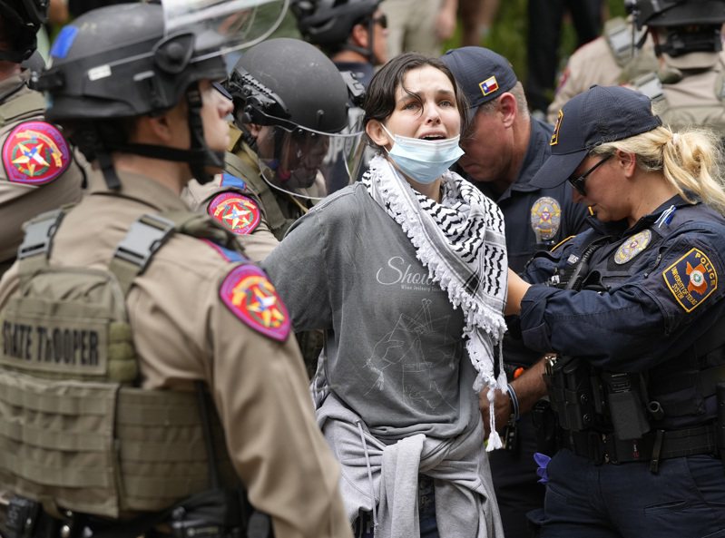美国德州大学奥斯汀分校24日传出示威学生和大批警力爆发肢体冲突，当局证实至少20人被逮捕。 图可见现场一名女性遭警方制伏逮捕。 美联社