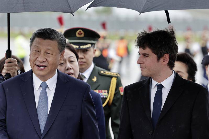 中国国家主席习近平(左)抵法，法国总理艾塔尔(右)接机。(美联社)