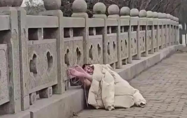 一女子全祼被绑在桥上，不停地发出呻吟，表情看起来十分痛苦。（视频截屏）