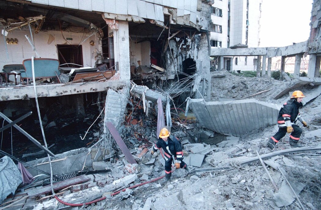 1999 年，中国驻贝尔格莱德大使馆遭到空袭，消防员在废墟中走过。