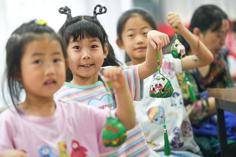 6月8日,山东省邹平市黄山街道月河社区的孩子展示自己制作的端午香囊。 (新华社)